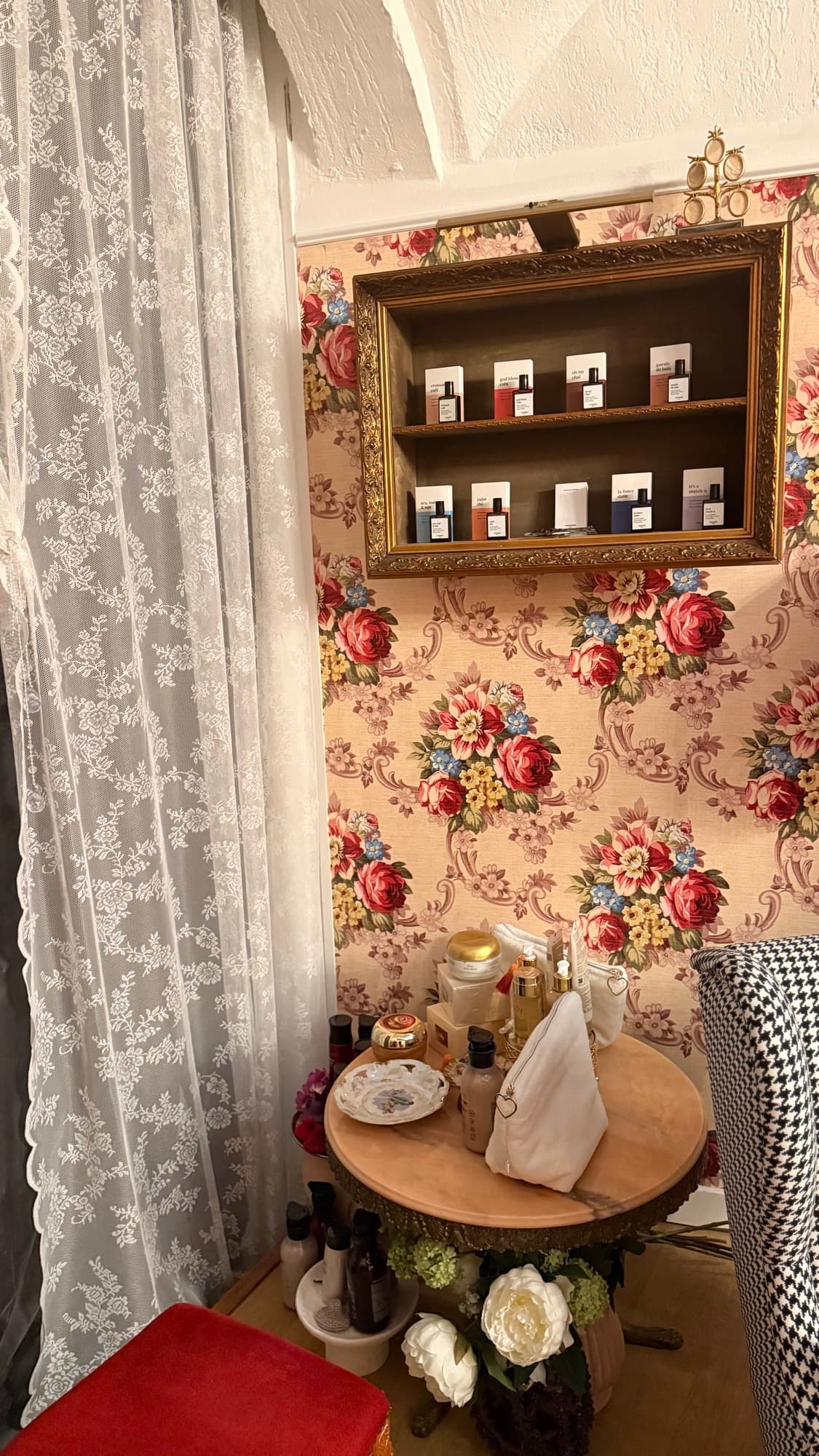 Vitrine à cadre doré présentant les parfums Versatile Paris